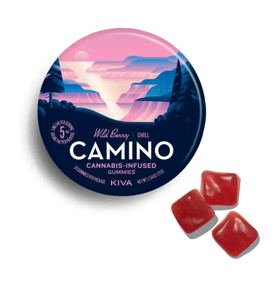 Round navy and pink KIVA Camino Wild Berry tin with a mountain landscape, next to three red square gummies.