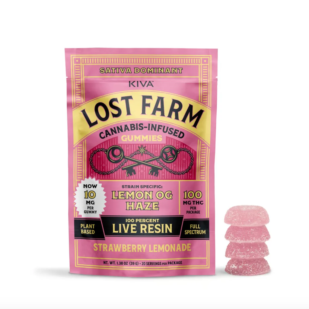 Pink KIVA Lost Farm Strawberry Lemonade pouch with Lemon OG Haze strain callout, beside a stack of pink gummies.