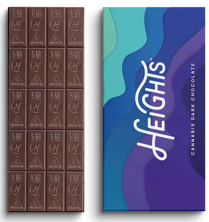 Dark chocolate bar scored into small squares next to a blue and purple Heights Cannabis Dark Chocolate wrapper.