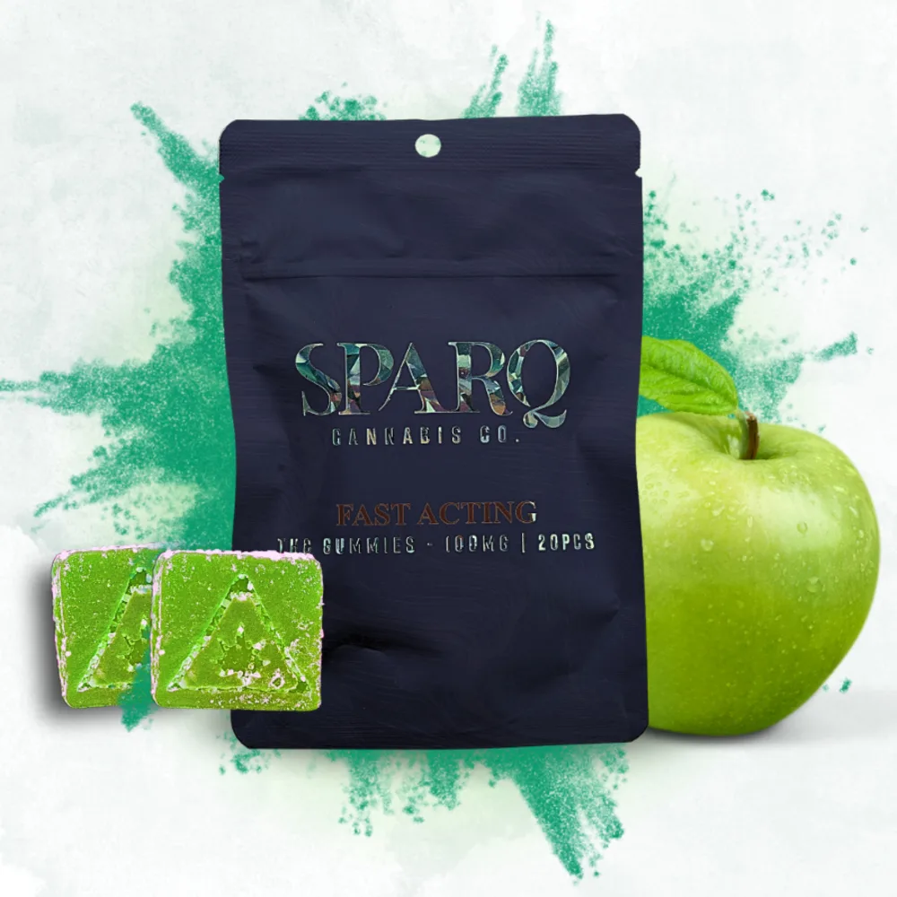 Black Sparq Cannabis Co. pouch with two square green gummies and a green apple, against a green powder splash.